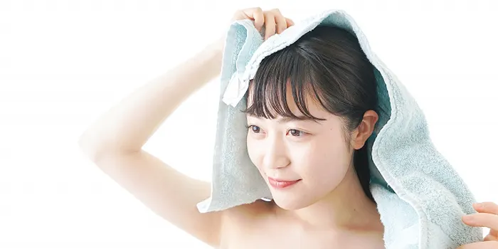 タオルで髪を拭く女性